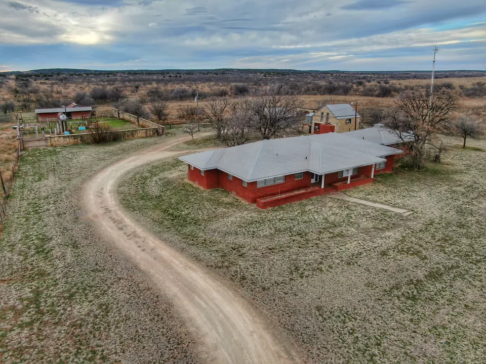Foard County farm property featuring a red brick ranch house and outbuildings on 2,746 acres in Foard County