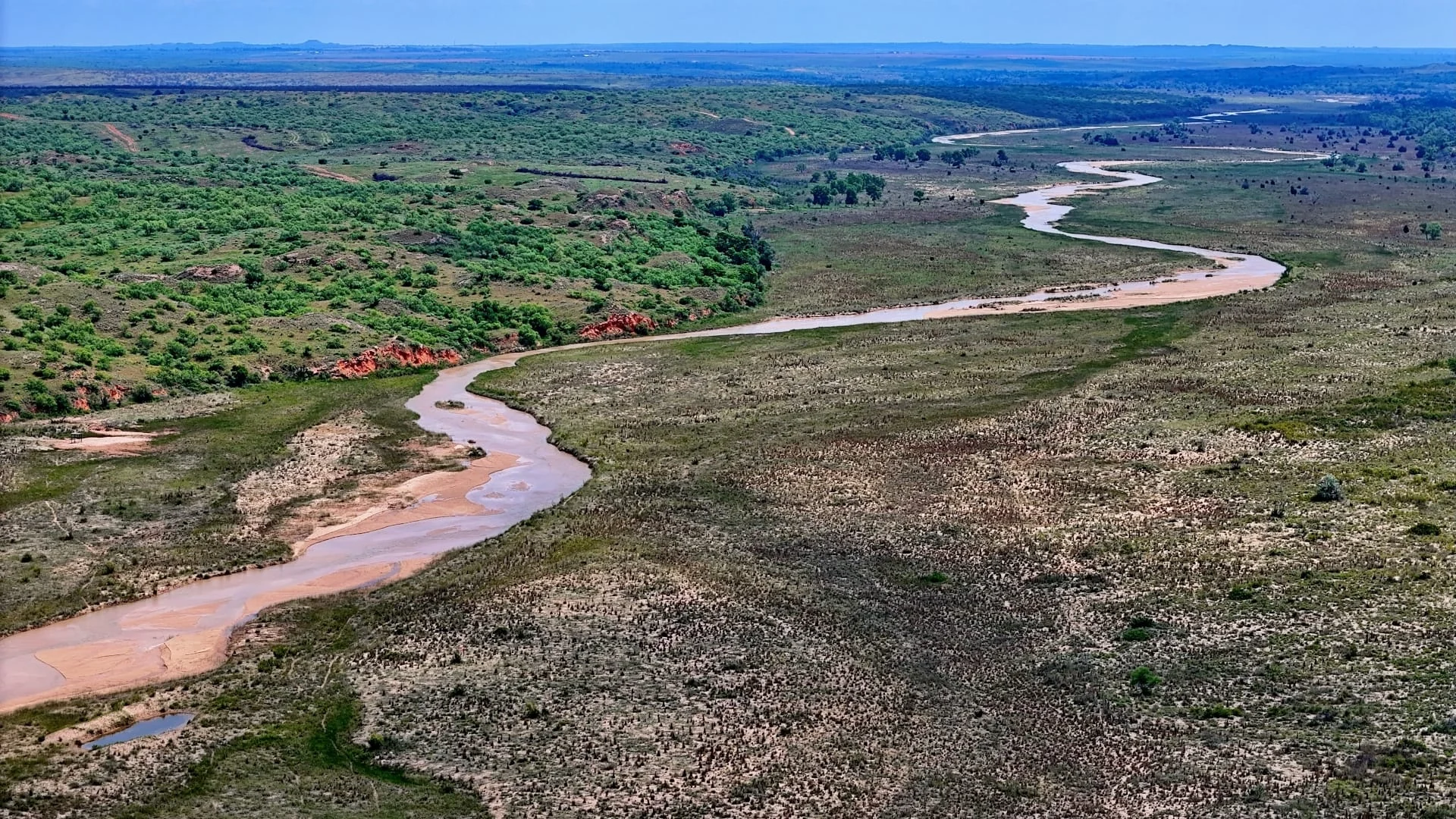 Aerial view of a river and rolling Texas ranch terrain