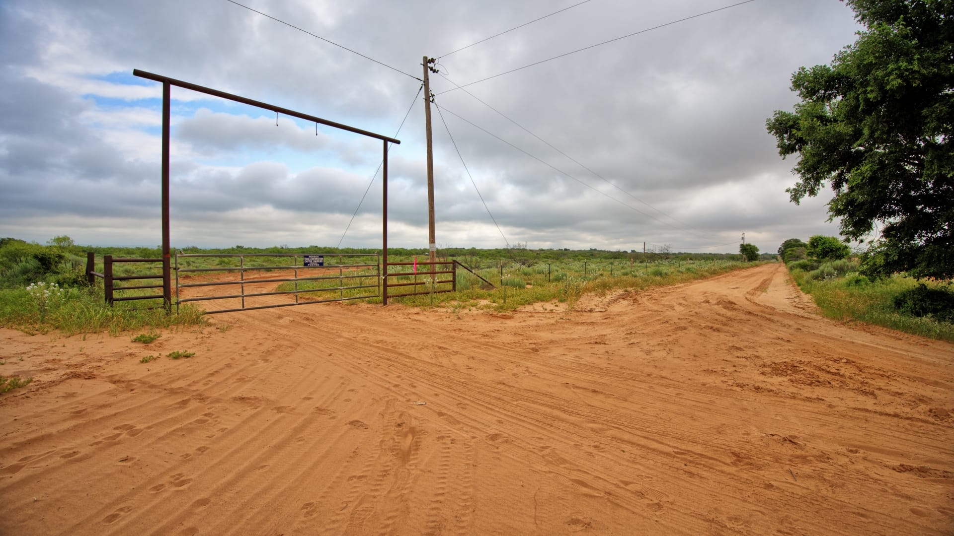 Sandy ranch road leading to a metal gate, 1,925 acres in Collingsworth County, TX