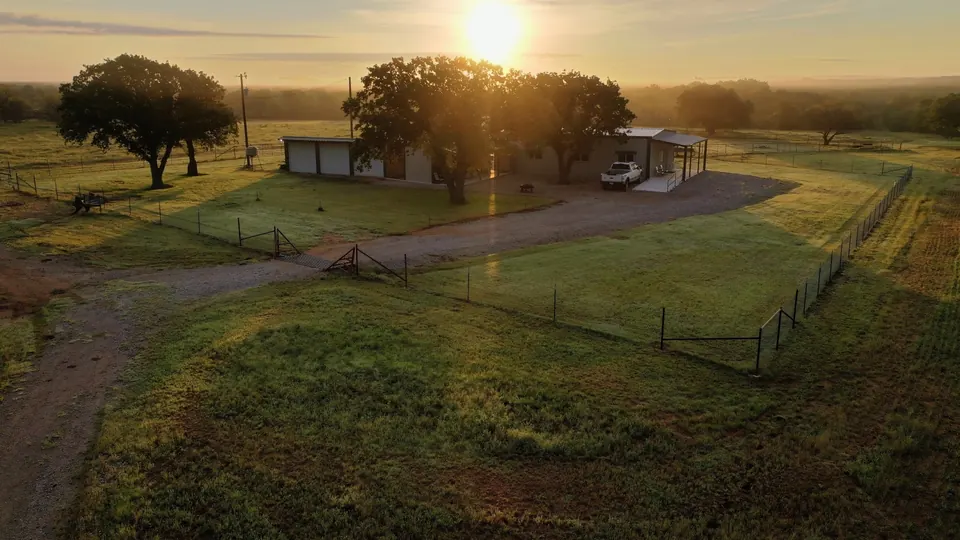 Sunrise over a fenced ranch property with a house, gravel drive, a, 435 acres in Clay County, 434.00 acres in Clay County, TX