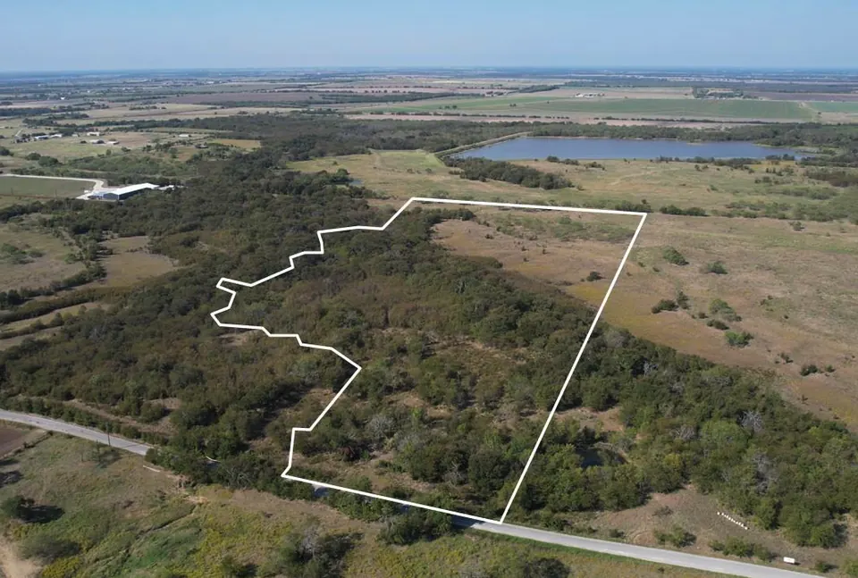 Texas ranch land outlined in white, featuring mixed trees and open pasture, with a pond in the distance, Texas ranch, Texas
